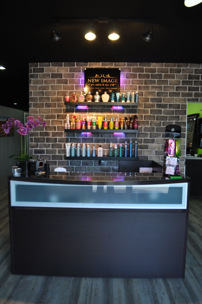 Front desk with a lit wall of tanning lotions